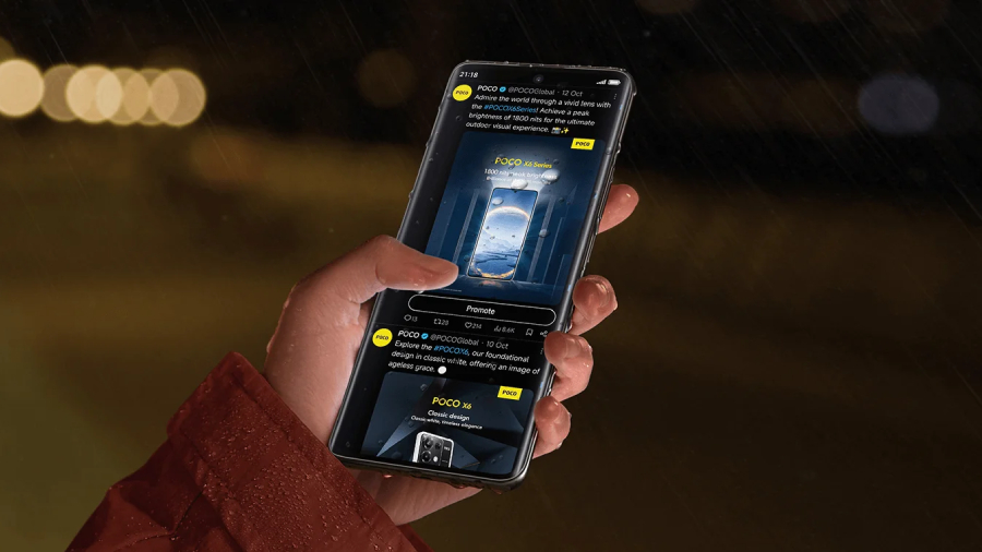 POCO X7 mokrý telefon držený v ruce venku v dešti