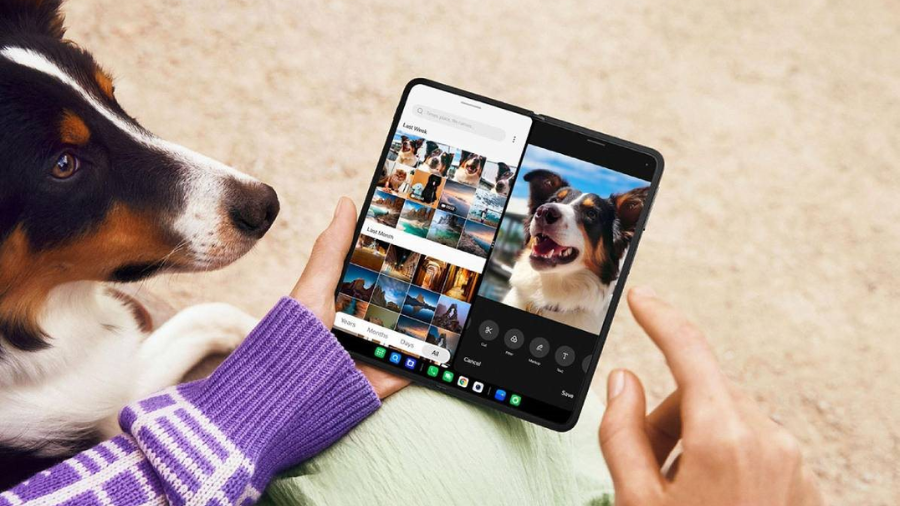 Osoba s rozevřeným telefonem OnePlus Open v ruce, kde je na rozděleném displeji zobrazená galerie a detailní fotka psa.