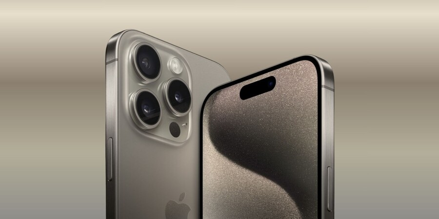 iPhone 15 Pro Max v barvě přírodního titanu. Jeden telefon je vidět zezadu, s výrazným trojitým fotoaparátem, zatímco druhý je zepředu, s viditelnou Dynamic Island. 
