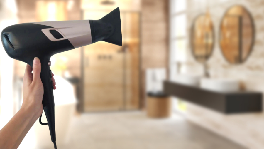 Rowenta Studio Dry Glow CV5831F0 v černé barvě v ruce ženy v koupelně.