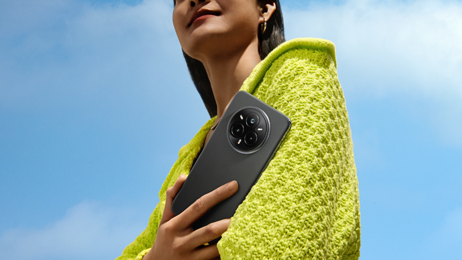 Osoba držící v ruce telefon Realme 14 Pro+ v černé barvě (Suede Grey).