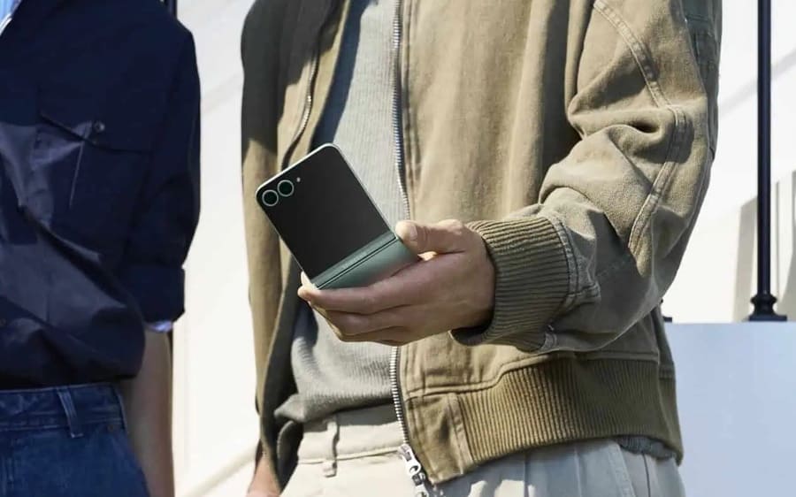 Muž drží v ruce Samsung Galaxy Z Flip6 v mátové barvě.