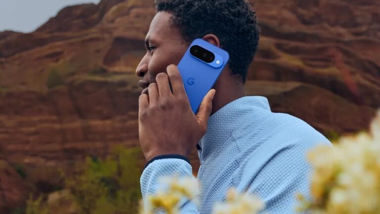 Muž drží v ruce modrý Google Pixel 10 a telefonuje.