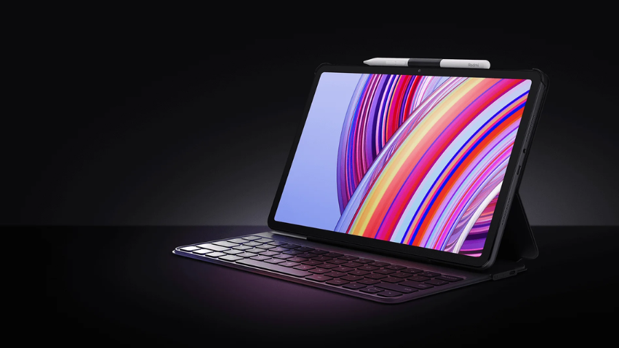 Tablet Xiaomi Redmi Pad Pro 5G s připevněnou magnetickou klávesnicí a dotykovým perem umístěným v horní části krytu.