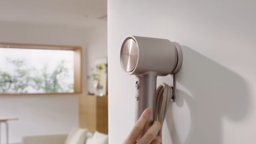 Fén Laifen Swift 4 na držáku přidělaném na zdi, který je součástí balení.