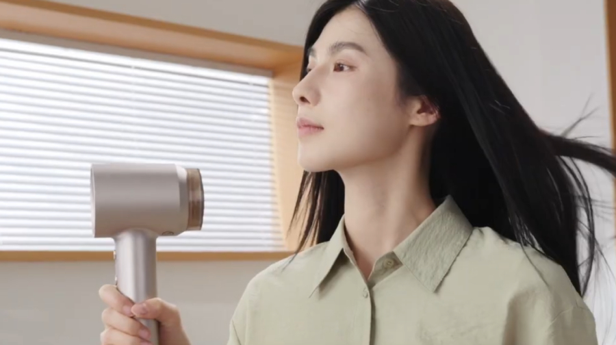 Žena s černými dlouhými vlasy foukající si vlasy fénem Laifen Swift 4.