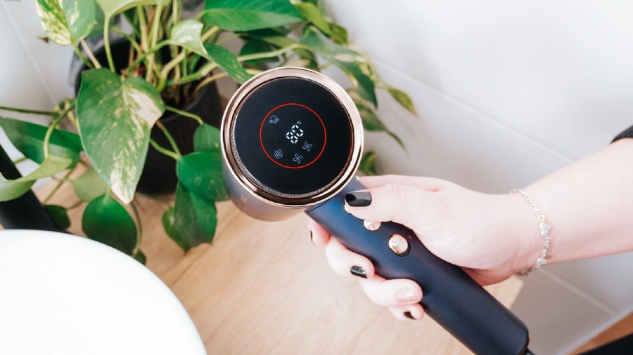 Pohled na fén Concept BLDC VV8100, který drží ženská ruka s nastaveným režimem teploty na 80°C.