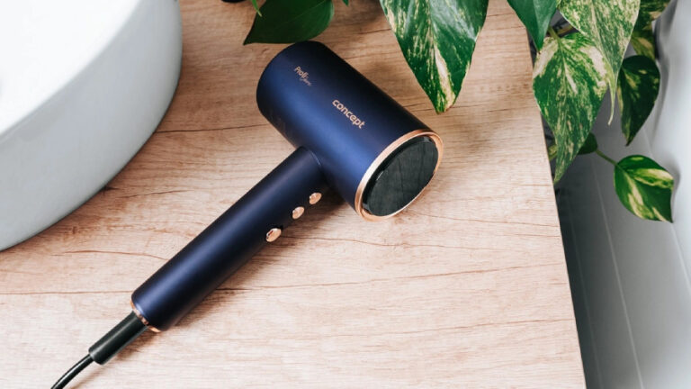 Fén Concept BLDC VV8100 v tmavě modré barvě položený na dřevěném stole.