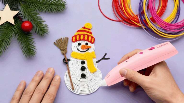 Růžové 3D pero LAMAX ArtKid1 v ruce tvoří sněhuláka z bílého filamentu na fialovém pozadí s vánoční dekorací.