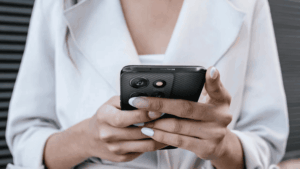 Žena drží v rukách telefon Motorola Moto G56.