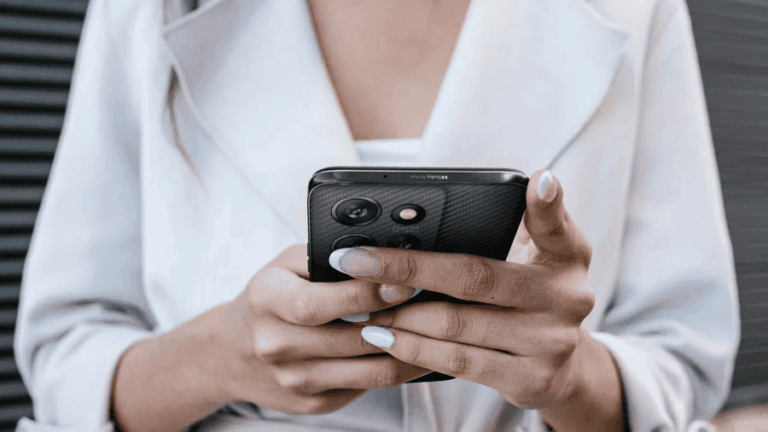 Žena drží v rukách telefon Motorola Moto G56.