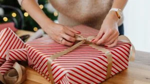 Žena balí vánoční dárek koupený v Black Friday akci.