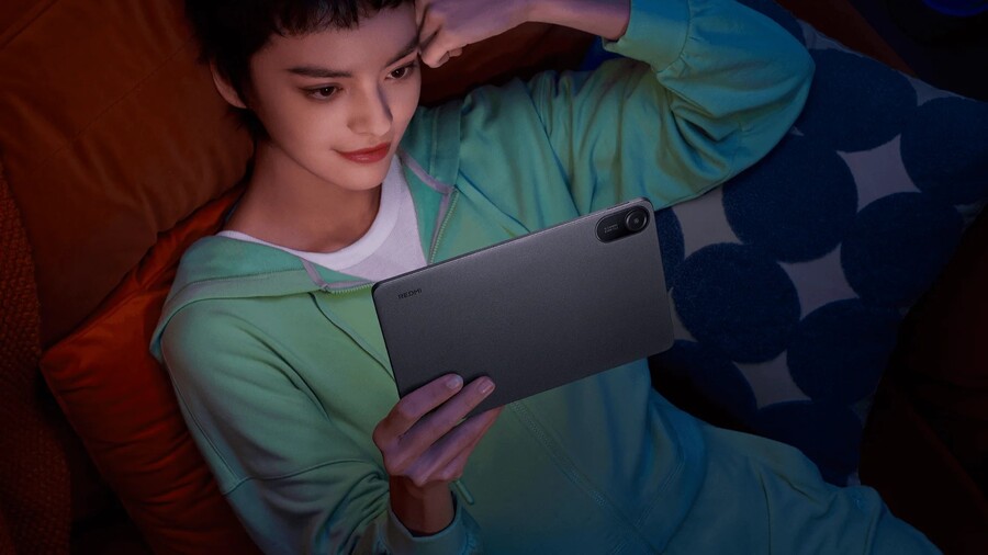 Žena odpočívá s tabletem Xiaomi Redmi Pad 2 v rukou, přičemž je vidět zadní strana s modulem fotoaparátu.