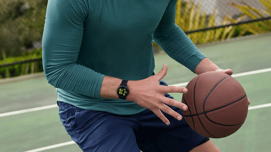 Muž hraje basketbal s hodinkami Garmin, které patří mezi nejlepší dárky pro muže