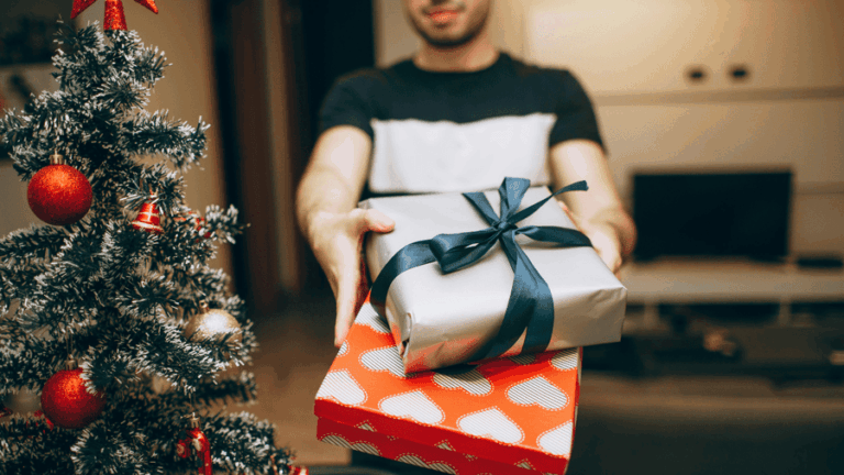 Muž přijímá nejlepší dárky pro muže u stromečku