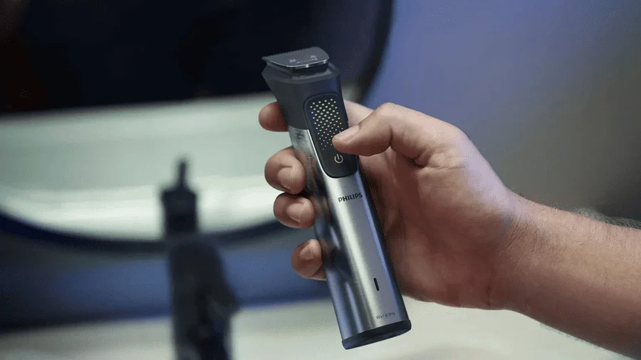 Muž drží v ruce holicí strojek Phillips - nejlepší dárky pro muže