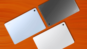 Zadní strana tří tabletů Samsung Galaxy Tab S10 FE v barvách: světle modré, tmavě šedé a bílé, ležící na oranžovém podkladu.