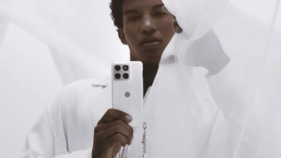 Muž drží v ruce telefon Motorola Edge 70 v barvě Cloud Dancer se Swarovski krystaly