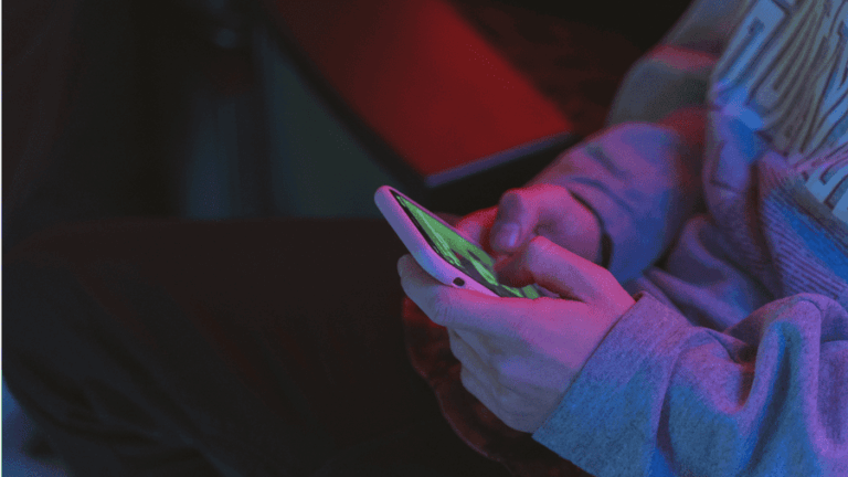 Muž drží v rukách telefon.