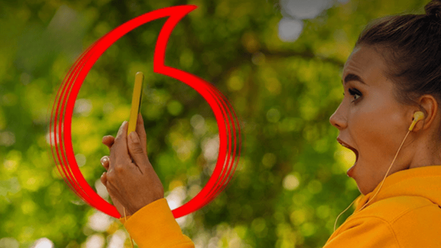 žena drží v rukách telefon s tarifem od Vodafone a sleduje aktuální nabídky operátorů