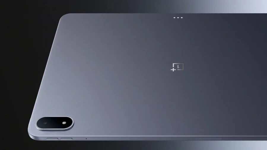 Zadní strana tabletu OnePlus Pad 3. V levém dolním rohu je vidět oválný modul hlavního fotoaparátu. Uprostřed se nachází logo OnePlus a v horní části jsou vidět tři kontaktní body pro připojení klávesnice.