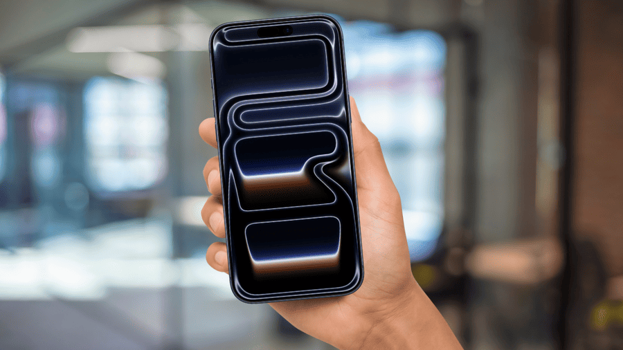 Muž drží iPhone 17 Pro Max v ruce, telefon má rozsvícený displej s výchozí tapetou.