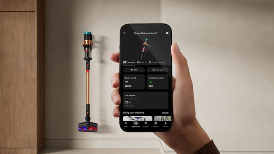 Detailní pohled na mobilní aplikaci MyDyson™ v chytrém telefonu, která v reálném čase zobrazuje stav baterie, nastavení výkonu a statistiky úklidu vysavače Dyson V16 Piston Animal viditelného v pozadí.
