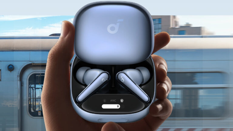 Pohled na otevřené bledě modré nabíjecí pouzdro, ve kterém jsou uložena špuntová sluchátka Soundcore Liberty 4 Pro ve stejné barvě. Pouzdro je drženo v dlaních a v jeho spodní části se nachází digitální displej s nápisem „ANC“ a indikátorem stavu. Na pozadí je rozmazaný jedoucí modrobílý vlak, což vizuálně zdůrazňuje funkci aktivního potlačení hluku v hlučném prostředí.