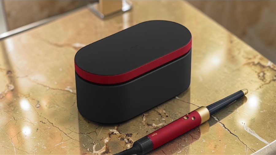 Luxusní balení multistyleru Dyson Airwrap i.d. v barevné variantě Red velvet na mramorovém podkladu s kónickým nástavcem.