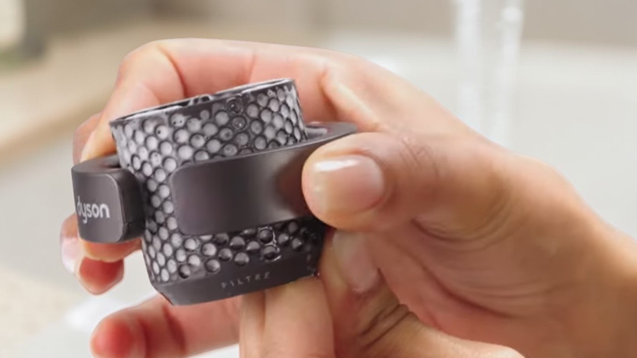 Detailní pohled na čištění vnitřního filtru Dyson Airwrap i.d. pomocí speciálního kartáčku pro zajištění maximálního výkonu.