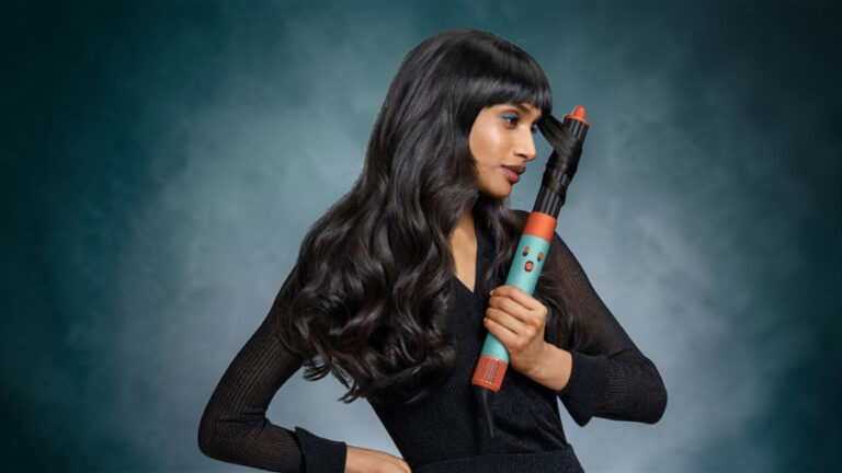 Modelka s dlouhými vlnitými vlasy používá Dyson Airwrap i.d. v barevném provedení Patina Topaz Orange pro tvorbu loken.