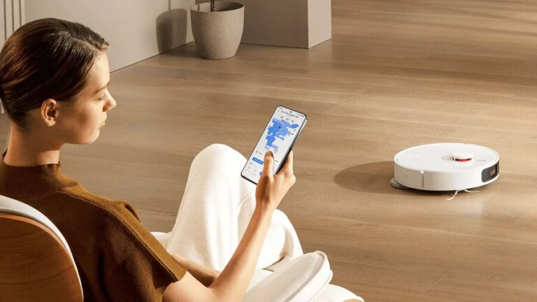 Srovnání robotických vysavačů do 10 000 Kč: Žena ovládající robotický vysavač Xiaomi Robot Vacuum X20+ pomocí mobilní aplikace s mapou domácnosti.