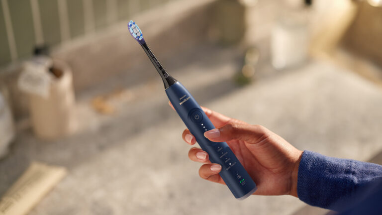 Žena ovládá zubní kartáček Philips Sonicare 7100 pomocí tlačítek