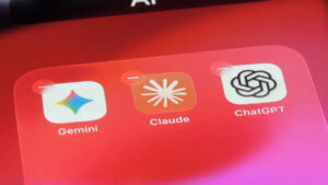 Tři ikony předních AI asistentů Gemini, Claude a ChatGPT uspořádané vedle sebe na rozostřeném červeném podkladu s nápisem AI v horní části.