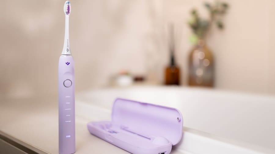Zubní kartáček TrueLife SonicBrush Clean70 UV ve fialové barvě postavený na okraji umyvadla
