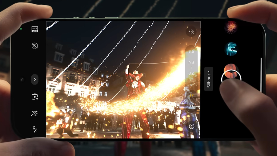 Detailní pohled na bezrámečkový displej telefonu Xiaomi 17 Ultra zobrazující aplikaci fotoaparátu při nočním focení kejklíře s ohněm a jasným uživatelským rozhraním.