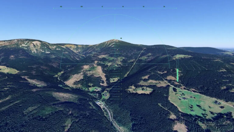 Letecký simulátor Google Earth zobrazuje virtuální let nad horskou krajinou Krkonoš s nejvyšší horou Sněžkou.