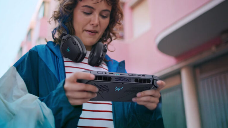 Mladá žena drží v rukou nový herní handheld Acer Predator Atlas 8 se sluchátky na krku.