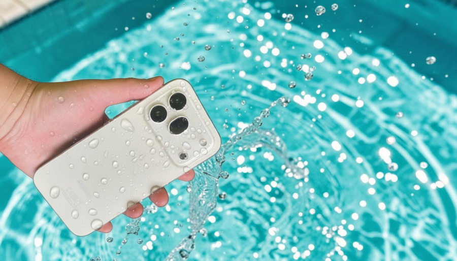 Mokrý smartphone HONOR 600 Pro s kapkami vody v ruce dokazuje špičkovou odolnost nad tyrkysovou hladinou bazénu.
