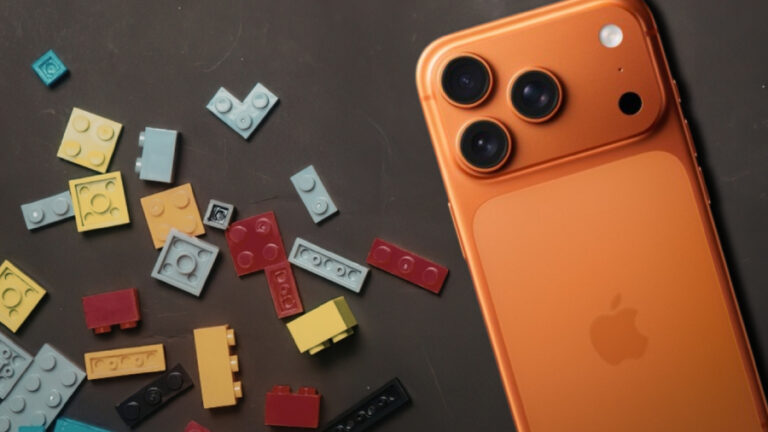 Oranžový mobilní telefon Apple iPhone položený vedle rozházených kostek stavebnice LEGO na tmavém pozadí ilustruje téma psychologie nákupu drahých produktů.