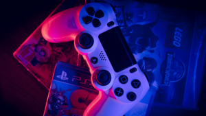 Ovladač od konzole PlayStation, pod kterým jsou disky s hrami