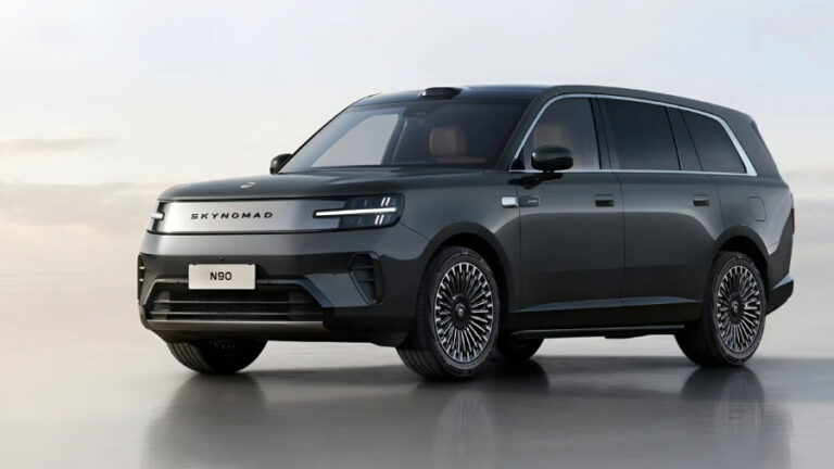 Tmavě šedé elektrické SUV Xiaomi SkyNomad stojící na hladké zrcadlící se podlaze pod světlou oblohou.
