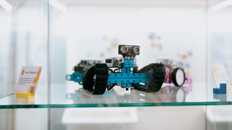 Pásový robot Makeblock vystavený ve skleněné vitríně, kterou v rámci oslav deseti let připravilo plzeňské centrum robotiky.