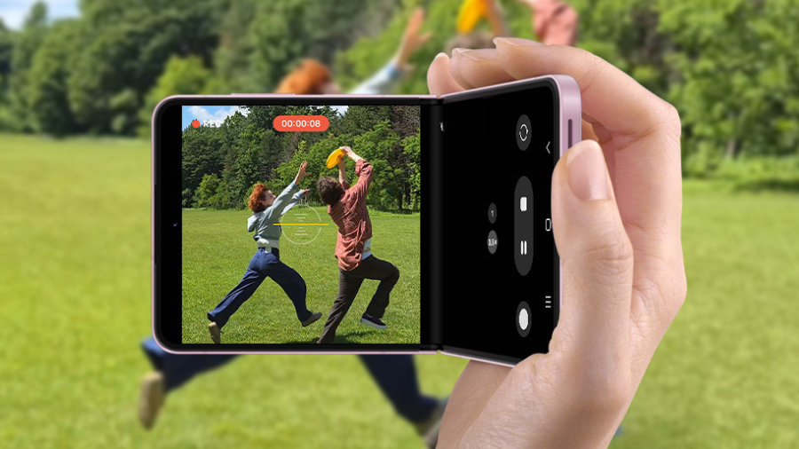 Detailní pohled na držení napůl ohnutého telefonu Samsung Galaxy Z Flip8 při natáčení videa v rozhraní Flex Mode.