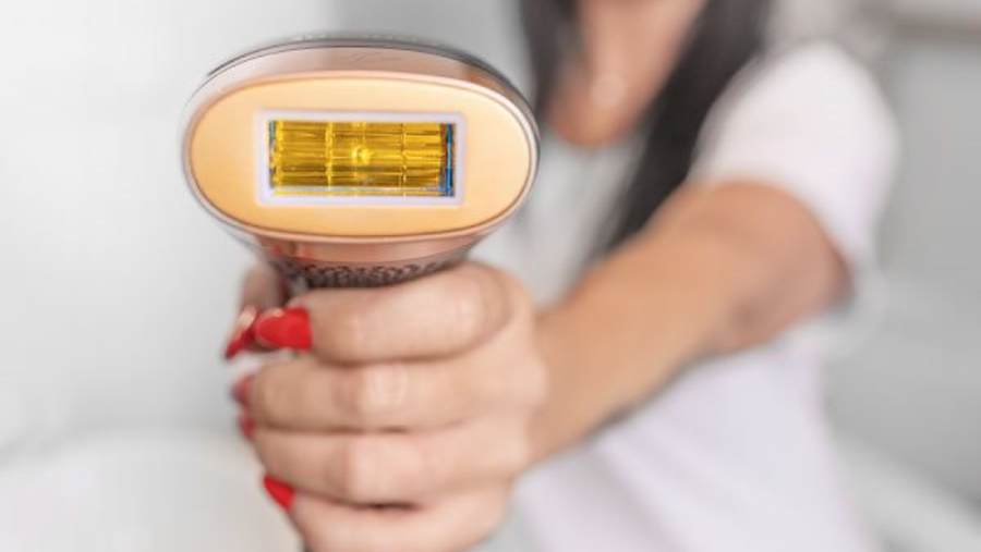 Detailní pohled na zábleskovou lampu a hlavní aplikační okénko IPL epilátoru Concept Perfect Skin PRO anti age IL5020, který drží žena v ruce.