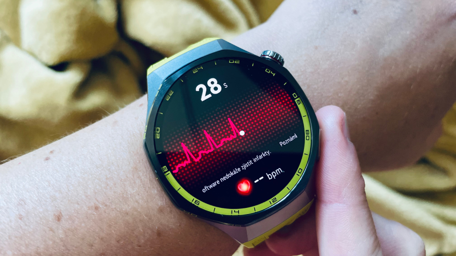 Detailní pohled na chytré hodinky Huawei Watch GT 7 Pro s olivovým řemínkem na zápěstí během spuštěného měření EKG s červenou křivkou srdečního rytmu na displeji.