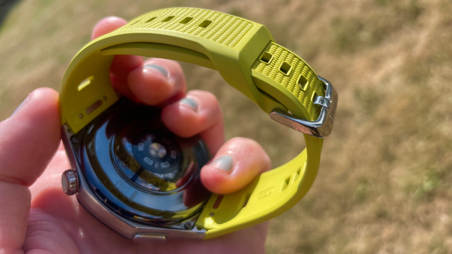 Pohled na spodní vyboulenou stranu hodinek Huawei Watch GT 7 Pro s olivovým řemínkem EasyCross, jehož konec se chytře zastrkává dovnitř pod pásek.