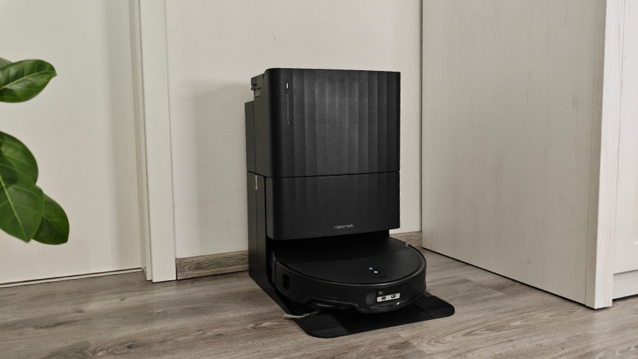 Černá multifunkční dokovací stanice Roborock Qrevo Edge 2 připojená u stěny s parkujícím robotickým vysavačem.
