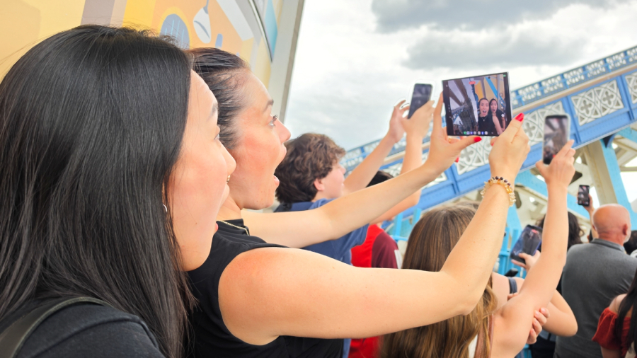 Skupina lidí fotografující okolí na londýnském mostě Tower Bridge, kde žena v popředí drží rozložený chytrý telefon Samsung Galaxy Z Fold8 Ultra a pořizuje selfie s překvapeným výrazem.