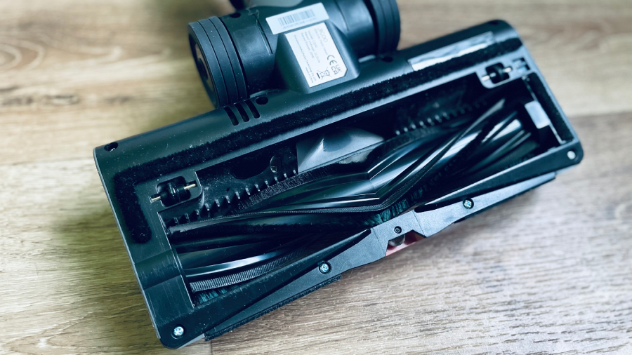 Pohled na spodní část podlahové hubice vysavače JIGOO C200 Cordless Vacuum Cleaner s rotačním kartáčem ve tvaru V a vodicími zuby proti namotávání vlasů.